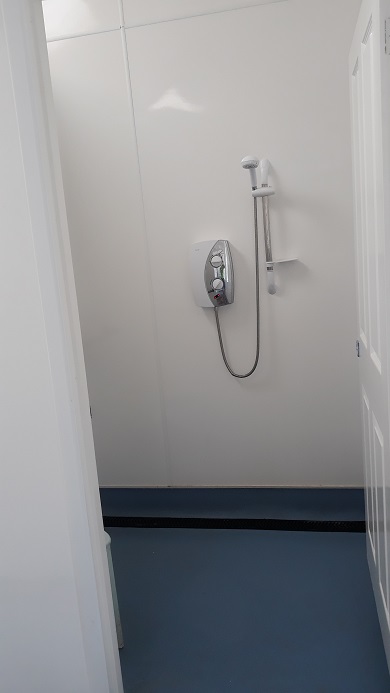 Shower in the building at the bottom of the hill